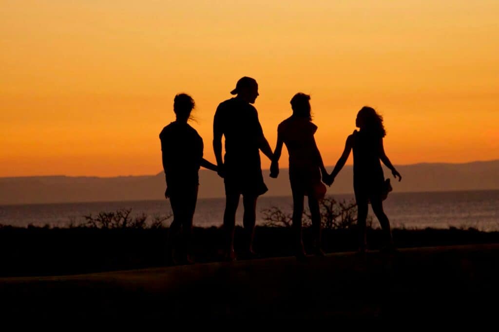 Famille sur la plage au soleil couchant